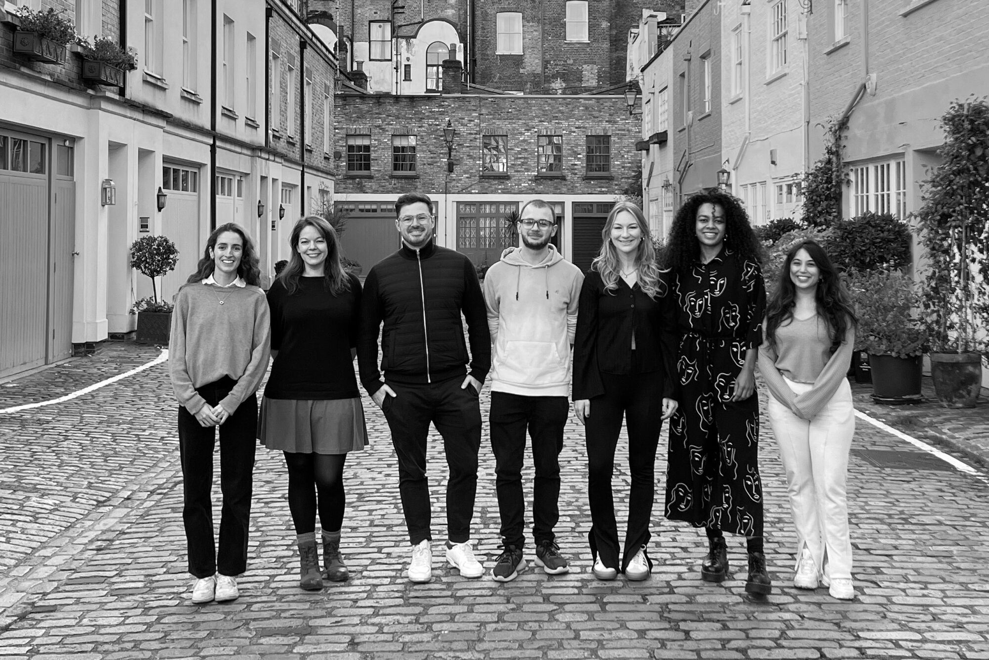 Group photo of the My/Architect team standing on a cobbled mews street.