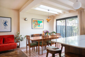 Open plan kitchen dining room with skylight, herringbone floor and mid-century furniture in Clapham extension
