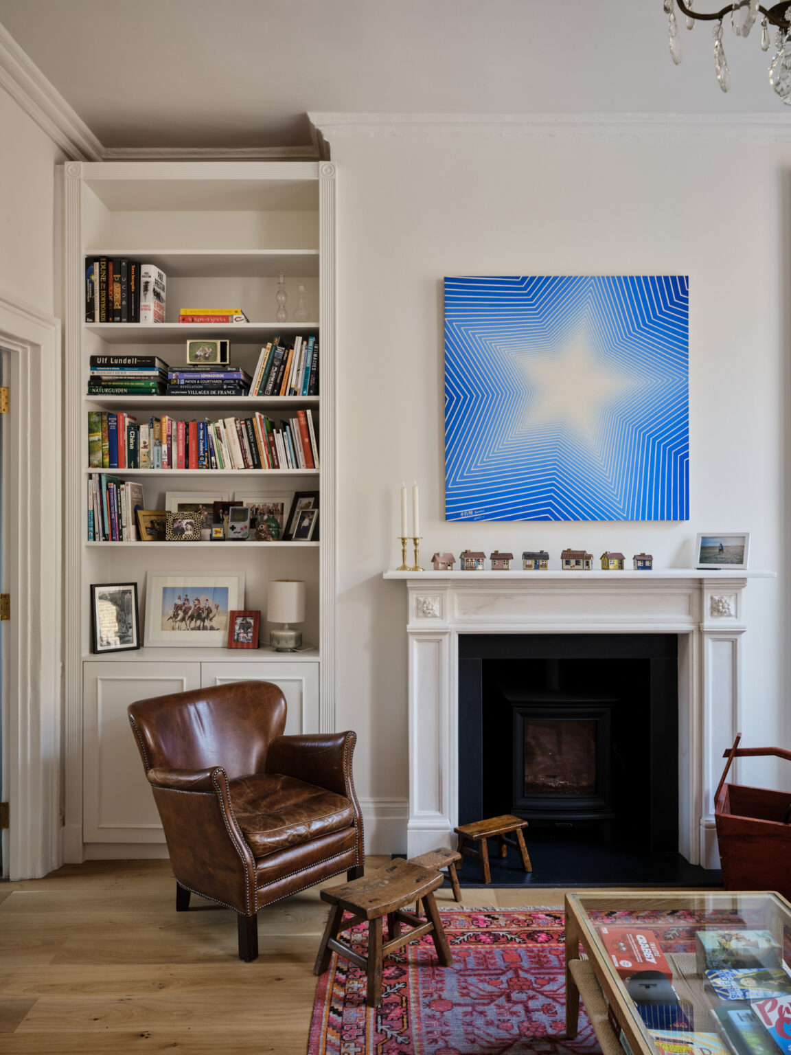 Reception room with Georgian fireplace bespoke shelving and contemporary blue artwork